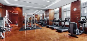 A gym with multiple treadmills, weight machines, and a mirrored wall. - Intercontinental Tangshan by IHG (Tangshan)