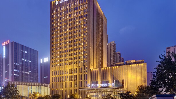 A high-rise hotel with a prominent "Intercontinental" sign at the top, featuring a modern architectural design with numerous windows and a well-lit facade. - Intercontinental Tangshan by IHG (Tangshan)