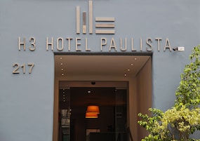 The exterior of H3 Hotel Paulista with a modern design, including a prominent entrance and a visible address number 217.