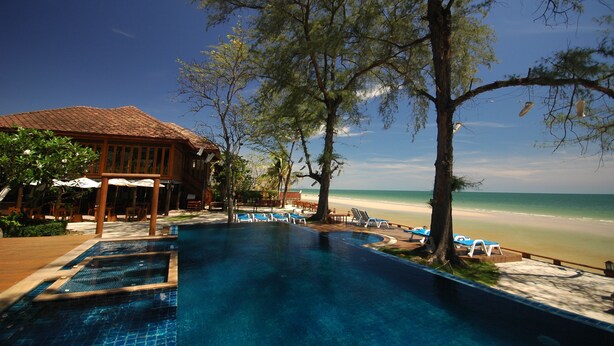 A pool area with lounge chairs and a view of the beach. - Baan Talay Dao (Hua Hin)