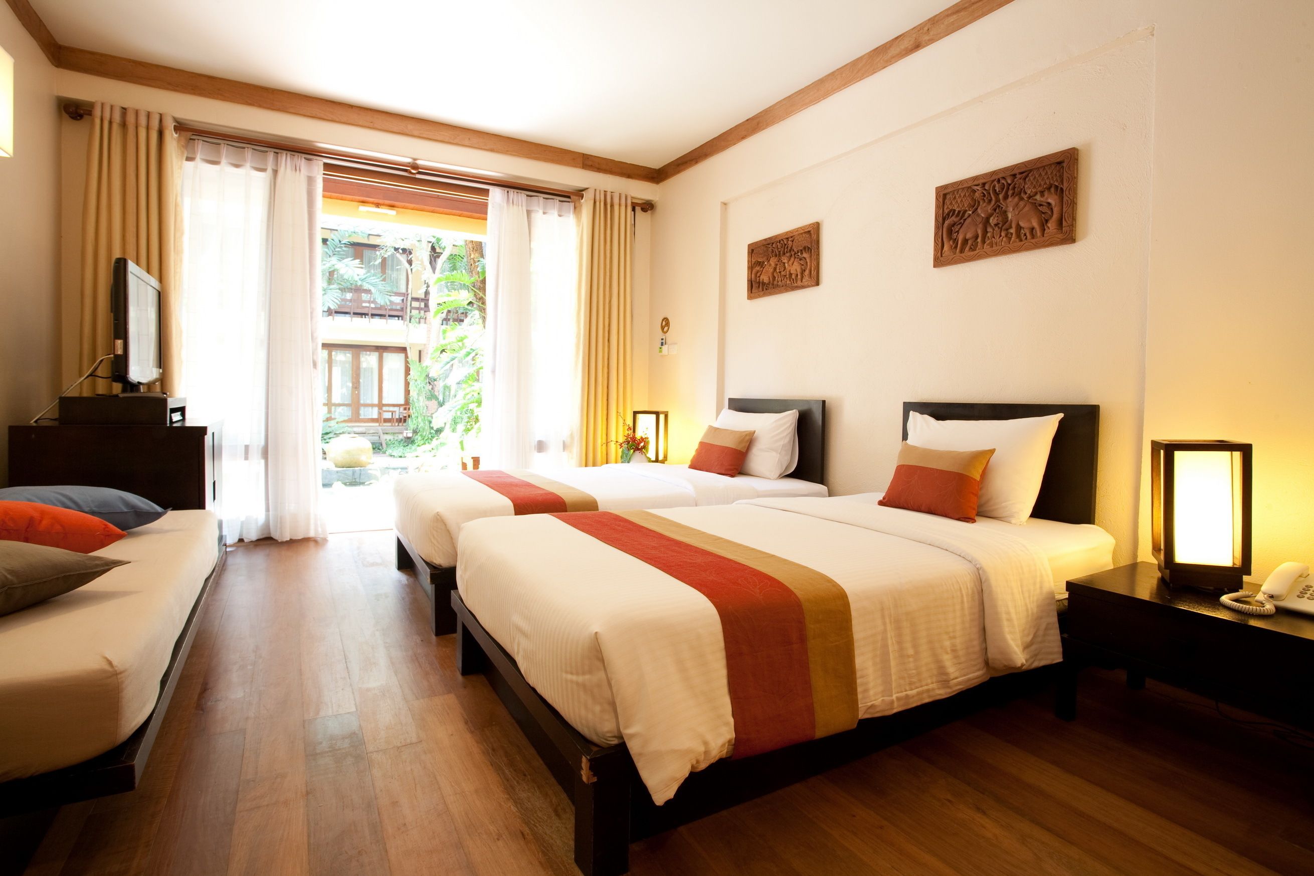 Une chambre d’hôtel avec deux lits, un bureau et une télévision.