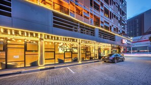 A modern building with a restaurant on the ground floor, featuring large windows and a car parked outside. - M2 de Bangkok (Bangkok)