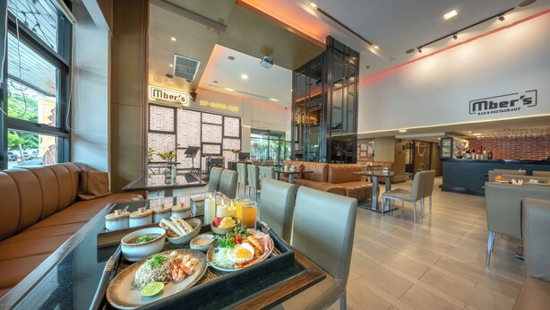 A restaurant with a bar area, seating arrangements, and a buffet table with various dishes. - M2 de Bangkok (Bangkok)