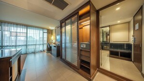 A modern hotel room with a large sliding door, a desk, a chair, and a view through the window. - M2 de Bangkok (Bangkok)