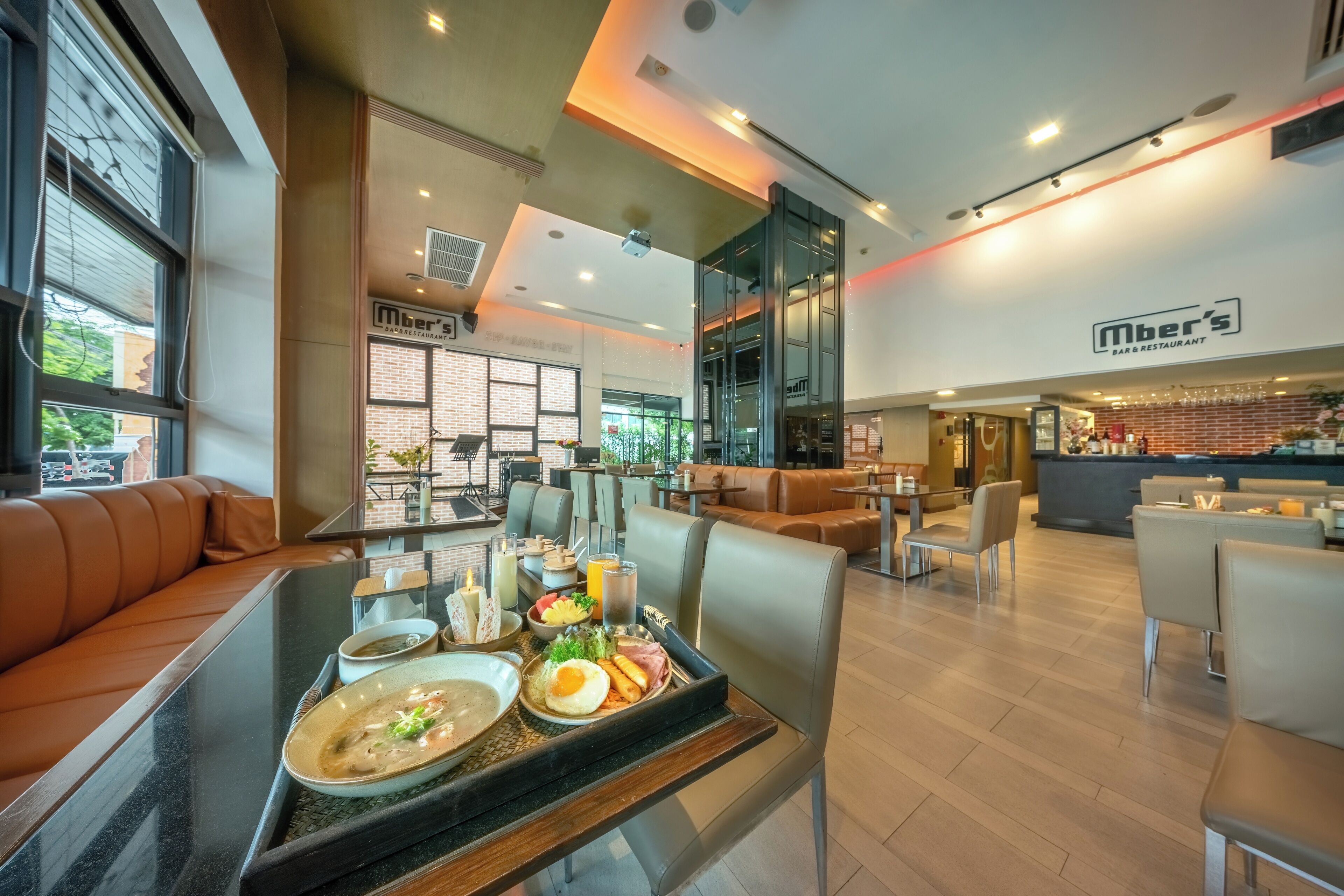 A modern restaurant interior with seating, a bar area, and a visible menu board.