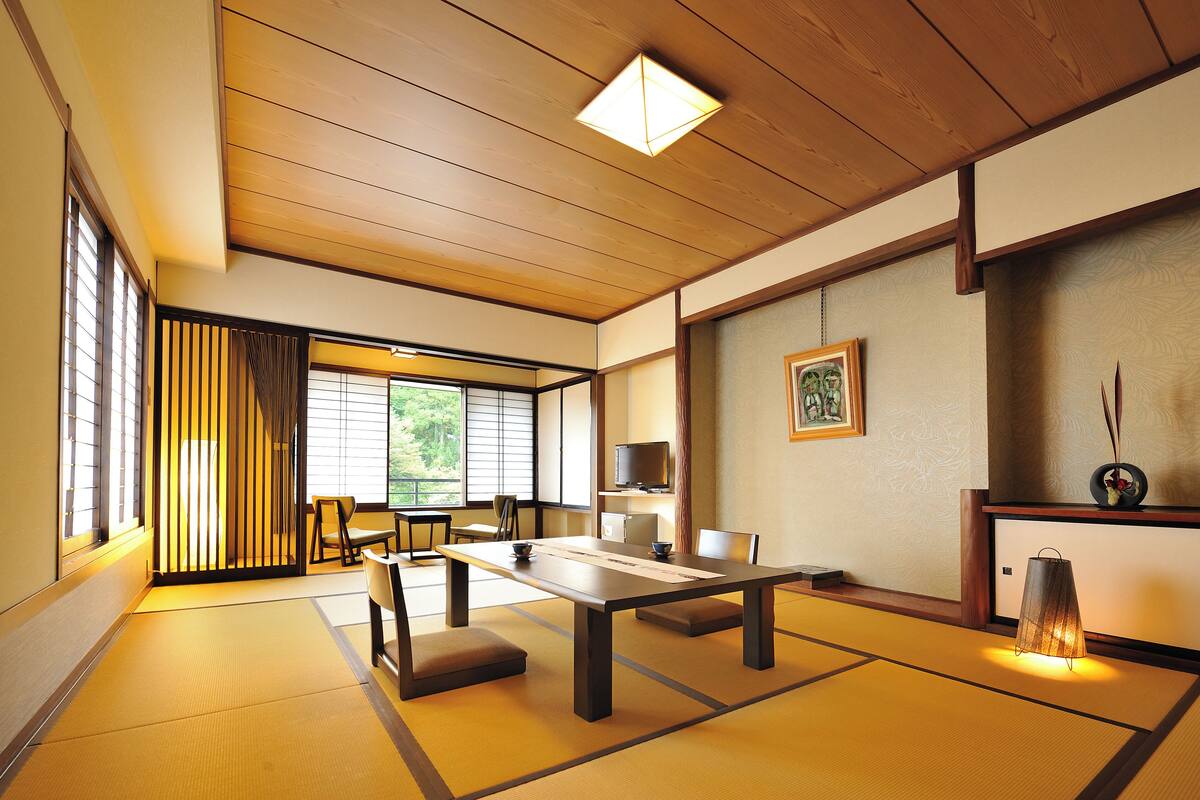 A traditional Japanese room with tatami flooring, a low table, and sliding doors.