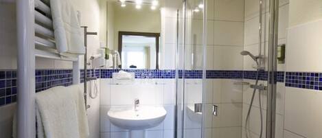 A modern bathroom with a glass shower enclosure, a sink with a mirror, and a towel rack.