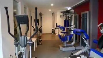 Ein Fitnessraum mit Laufbändern, Crosstrainern und Krafttrainingsgeräten.