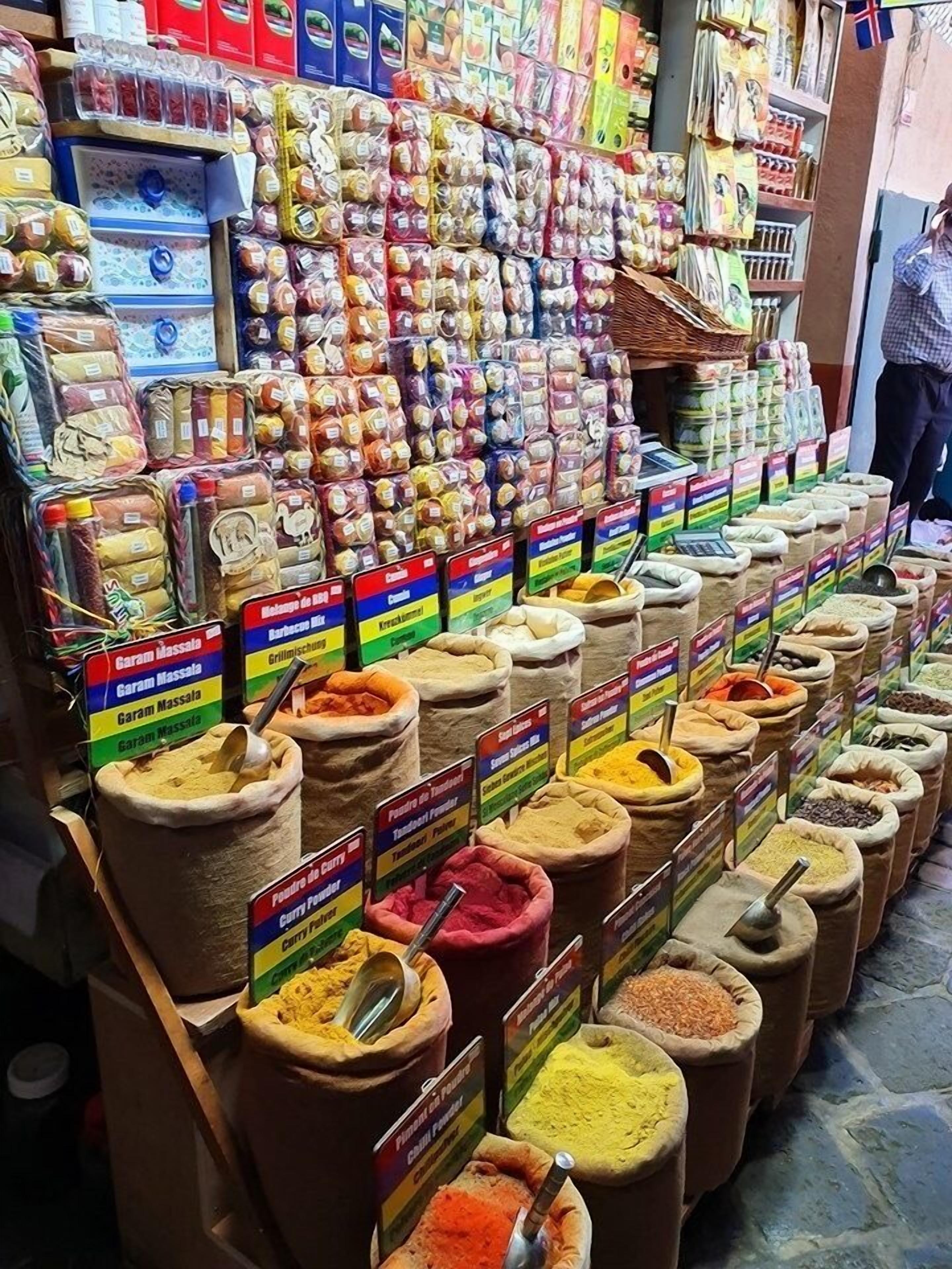 A spice shop with various spices displayed in sacks and labeled with their names.