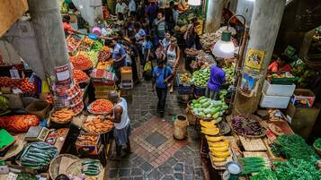 Un mercado animado con varios puestos que ofrecen frutas y verduras frescas.