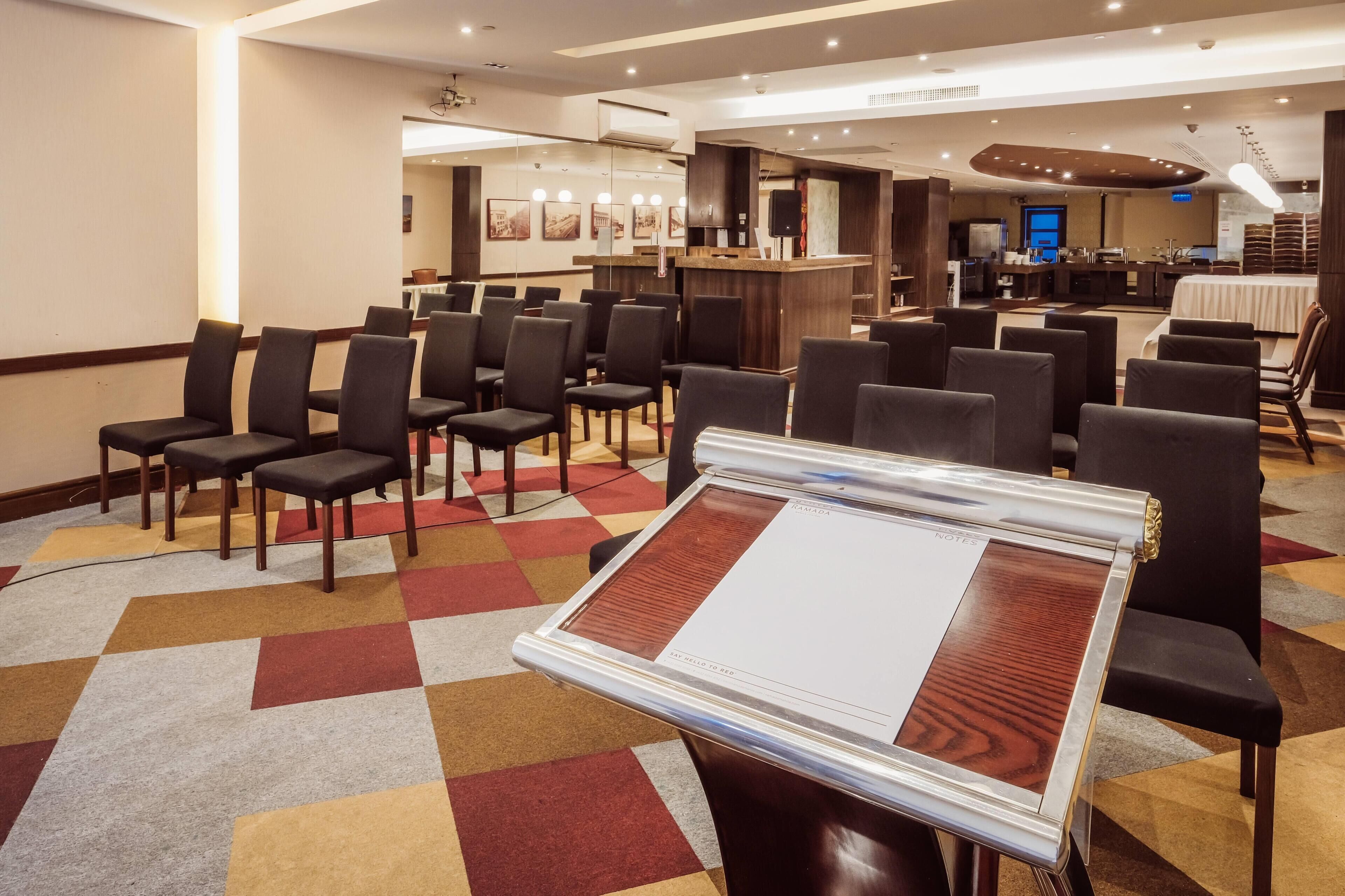 A hotel lobby with a reception desk, seating area, and a buffet.