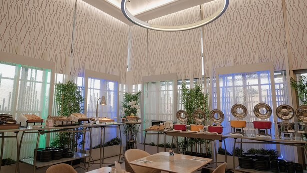 A modern interior with patterned walls, large windows, and tables with various items. - Ramada by Wyndham Manila Central (Manila)