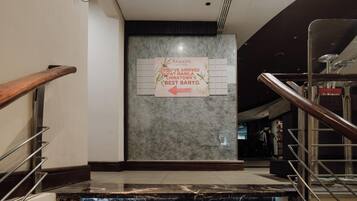 A marble staircase with metal railings leading to a lobby area featuring a sign indicating the arrival at Manila Chinatown's Best Banyo.