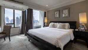 Une chambre d’hôtel avec un grand lit, une chaise, une table de chevet avec une lampe et une vue sur le panorama de la ville.