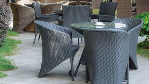 Une terrasse extérieure avec des meubles en osier et des parasols.