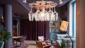 Una sala de estar moderna con una lámpara de techo original, asientos cómodos y un ventanal grande.