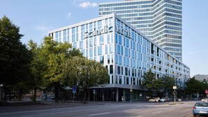 Un hotel moderno con fachada de vidrio y un llamativo letrero de "Scandic".