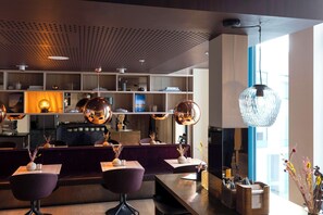 Een modern interieur met een bar, zitplaatsen en een groot raam.