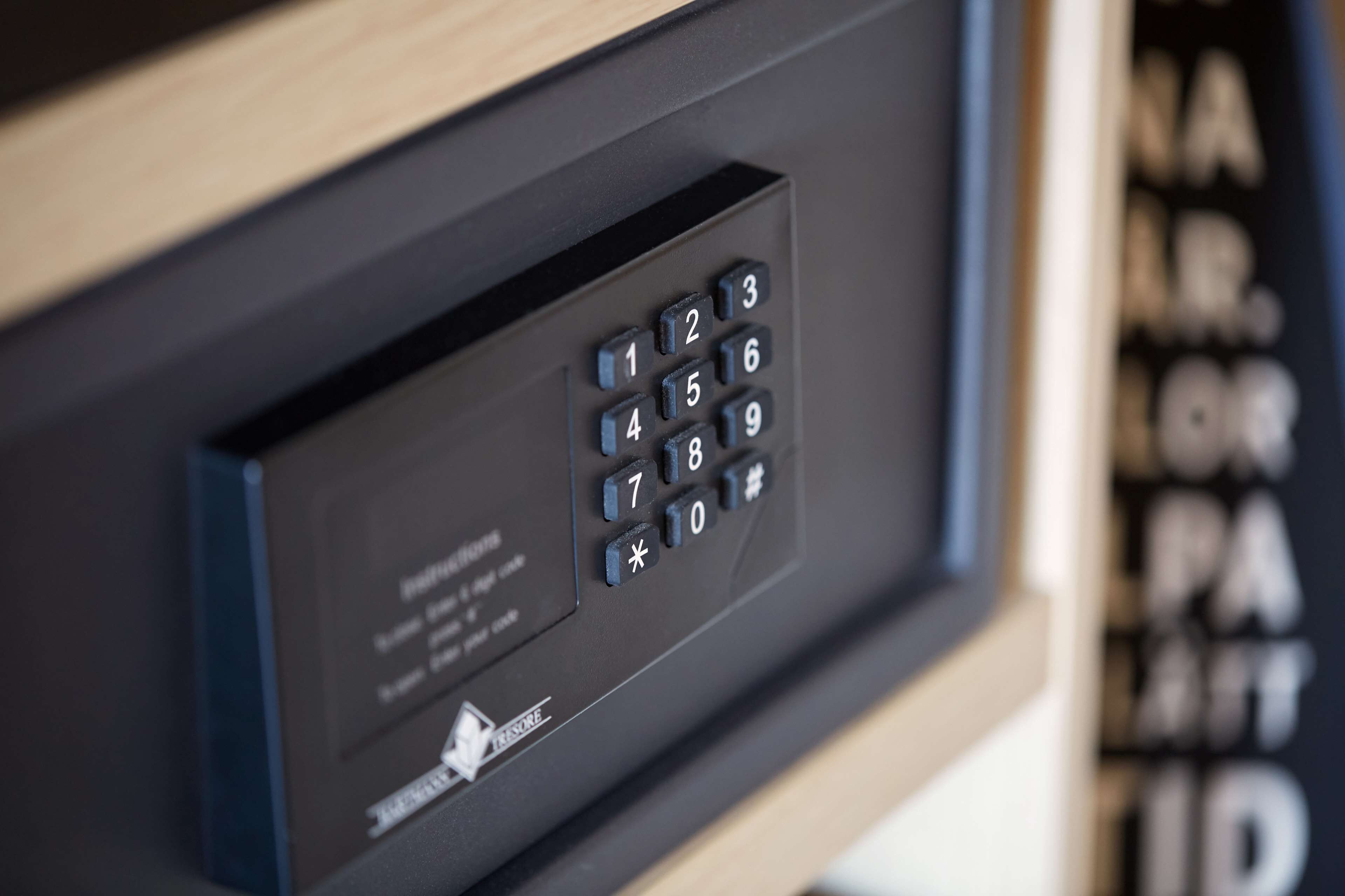 A close-up of a keypad lock on a door, with a small logo and text indicating it is a secure entry point.
