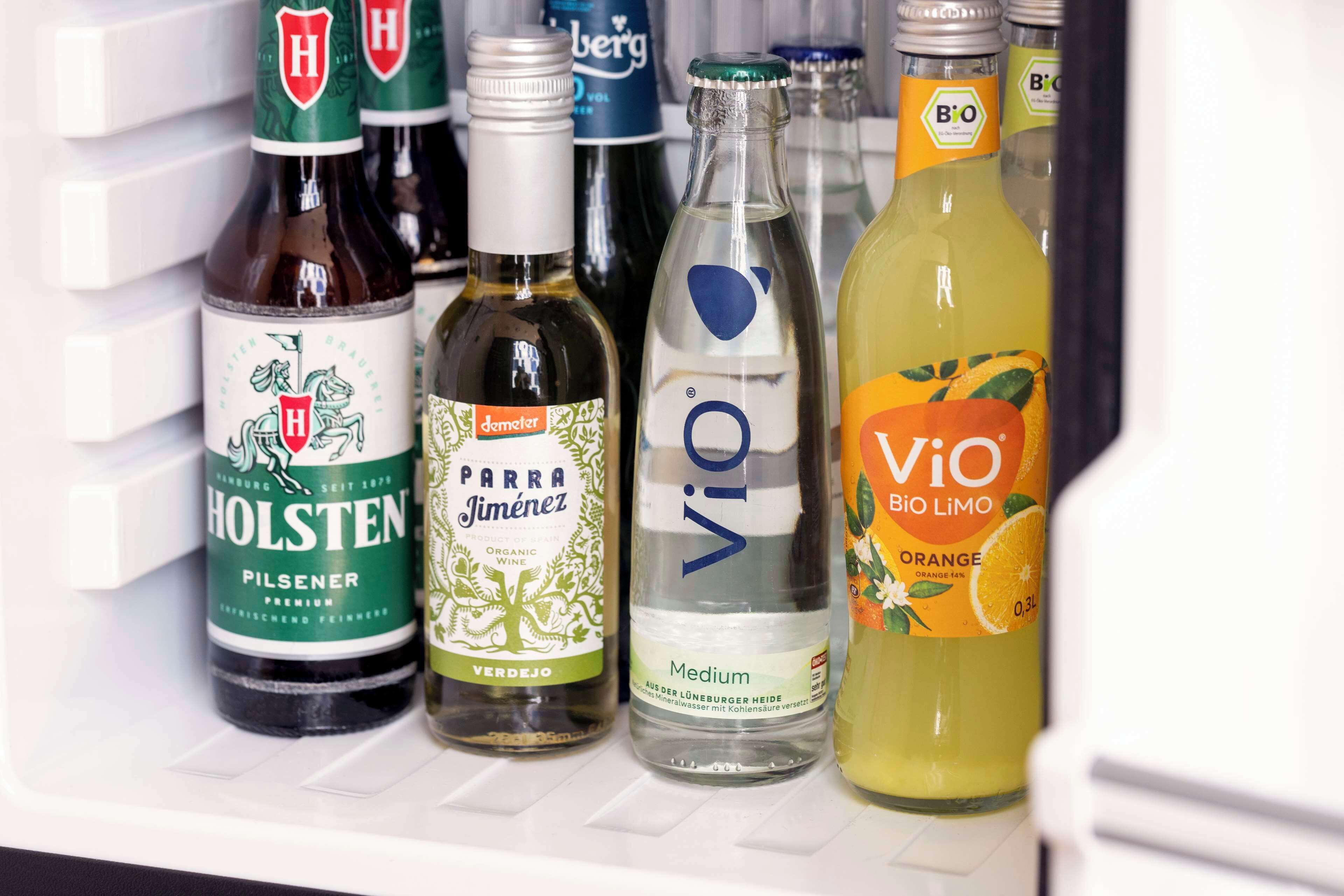 A refrigerator stocked with various beverages including Holsten Pilsener, Parra Jimenez, Vio, and Vio Bio LiMO.