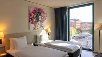 Ein Hotelzimmer mit zwei Betten, einem großen Fenster mit Blick auf die Stadt und einem Gemälde an der Wand.