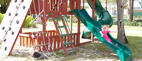 A playground with a slide and climbing wall.