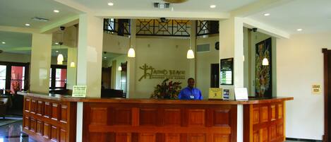 A reception desk with a sign for 'Ritchey Beach Resort and Club' and a 'Luggage Room' sign.