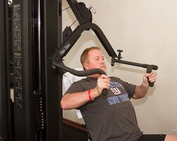 Un hombre usando una máquina de gimnasio.