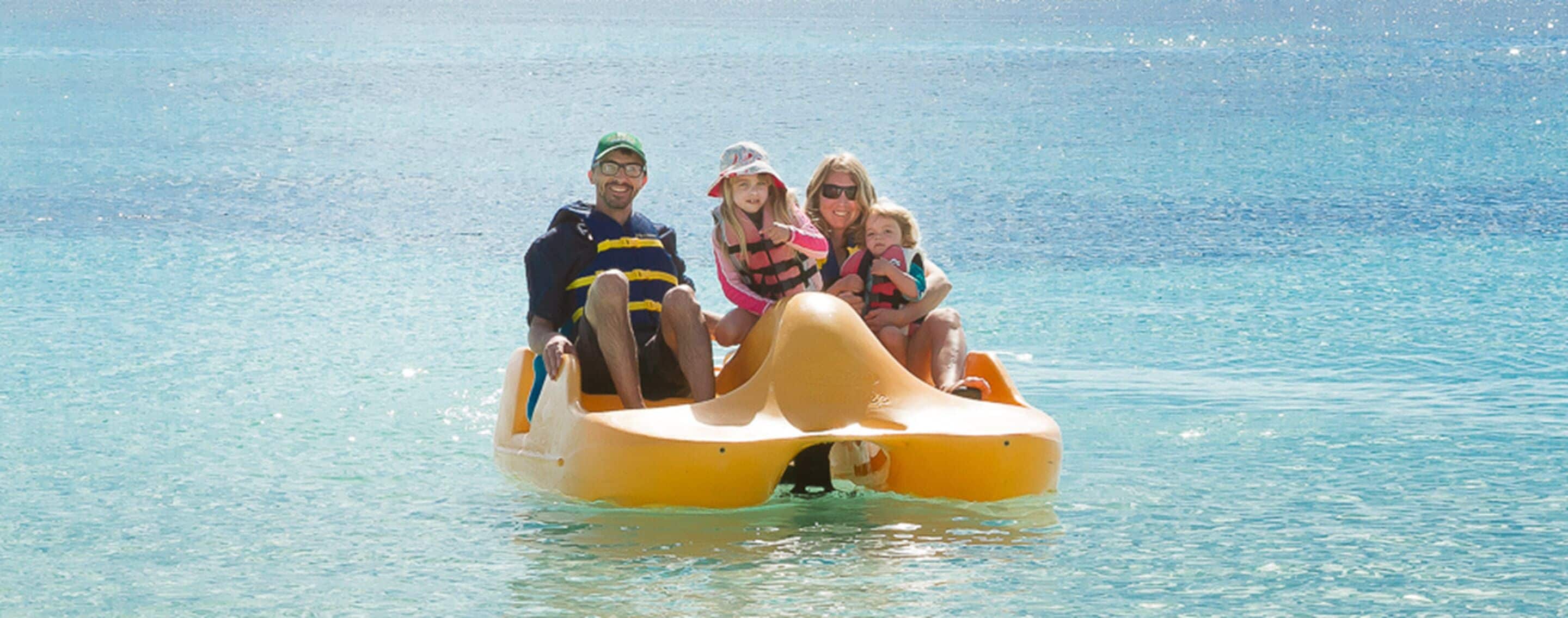 A family on a yellow raft in a body of water.