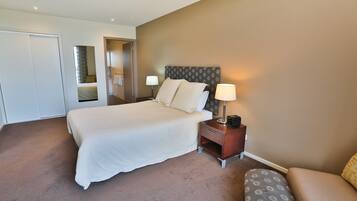 Een hotelkamer met een groot bed, nachtkastjes en een bank.
