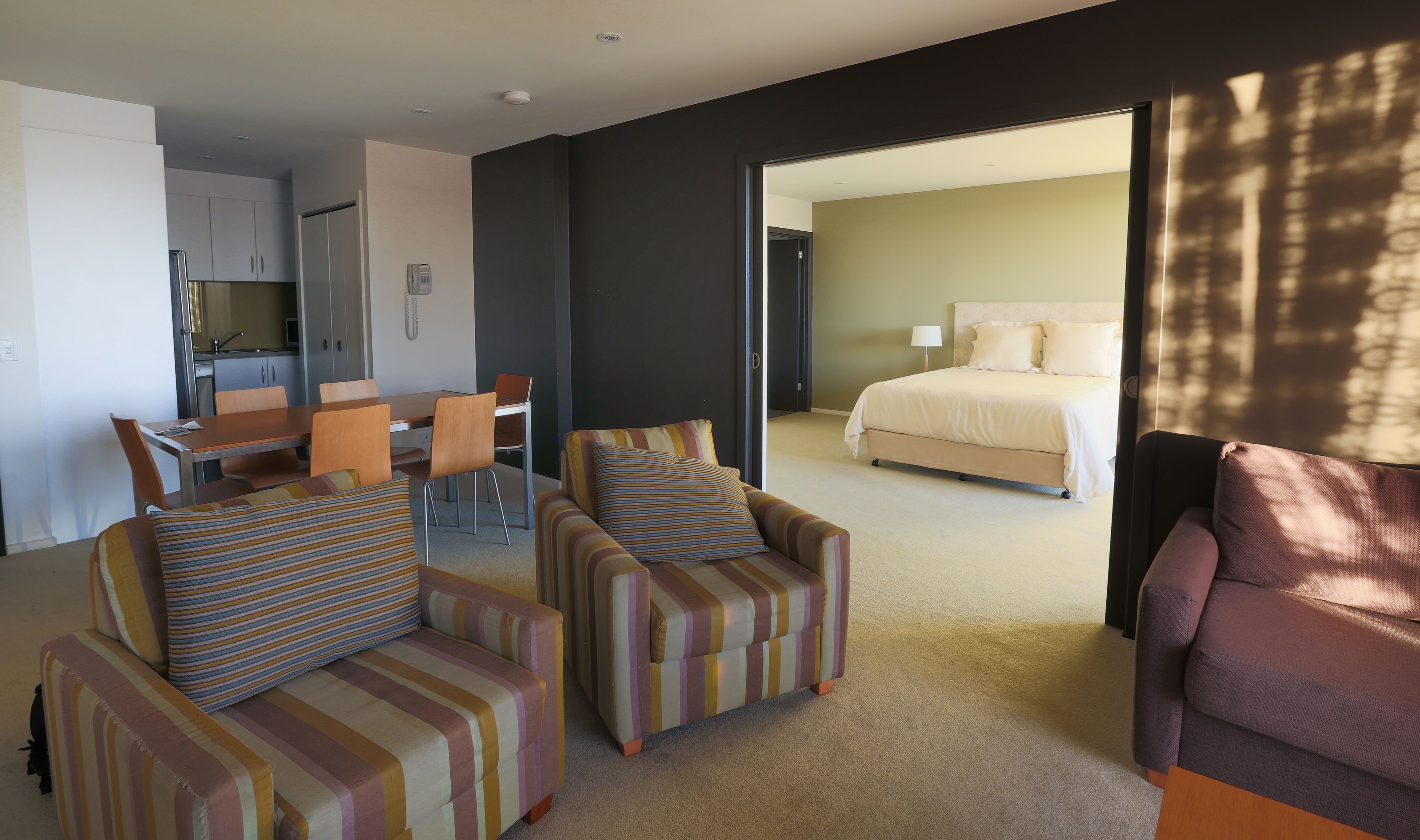 A hotel room with a dining area, a bed, and a sofa.