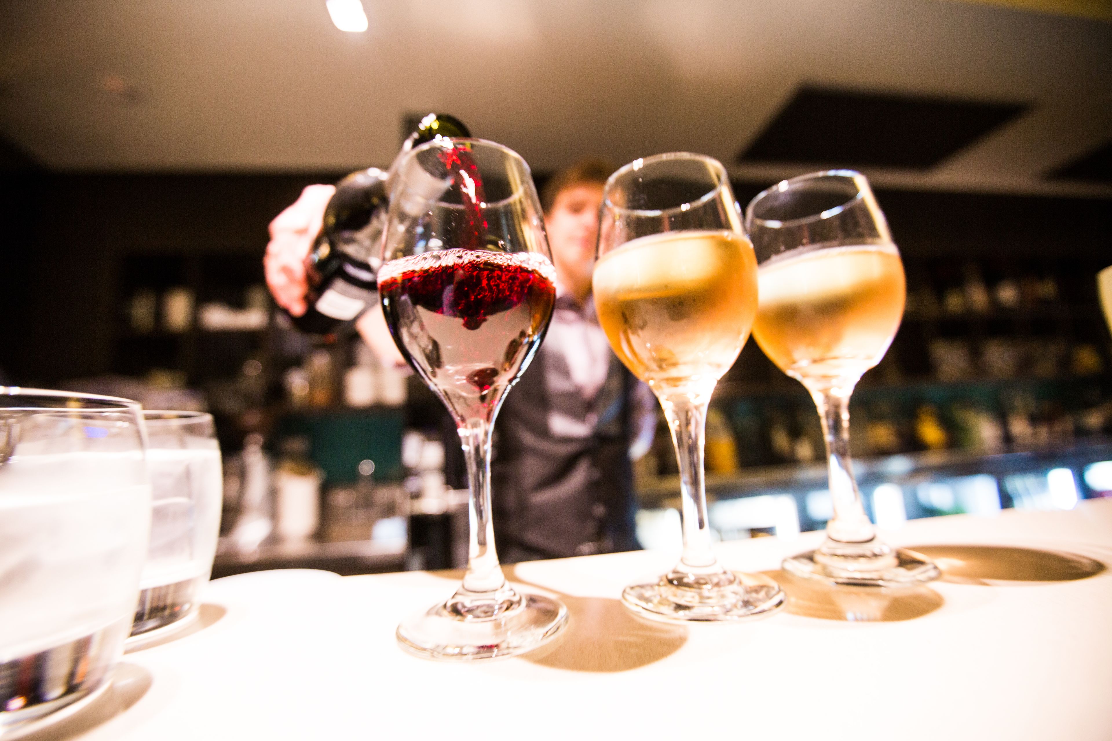 Un bar con varias copas de vino sobre una barra.