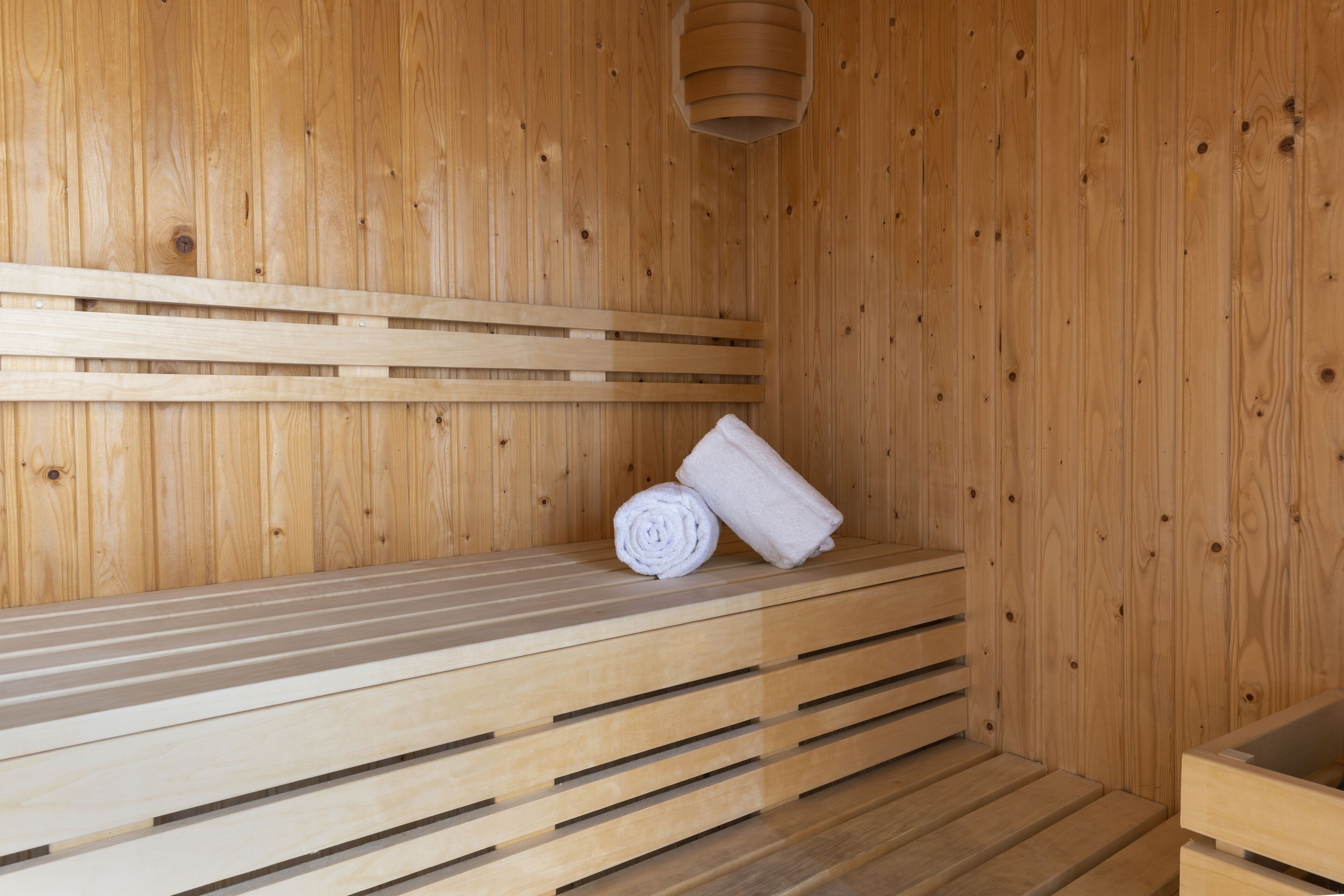A wooden sauna with benches and a towel.