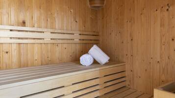 Een houten sauna met banken en een handdoek.
