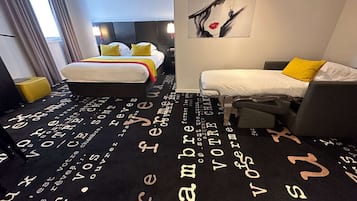 Ein Hotelzimmer mit Bett, einer Couch und einem Kunstwerk an der Wand.