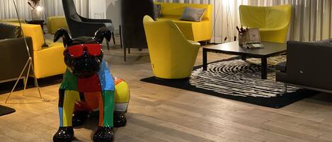 A modern living room with yellow and black furniture, a zebra-patterned rug, and a decorative glass sculpture.