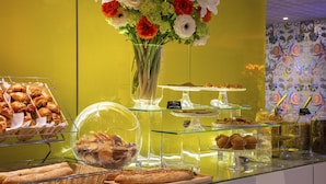 A bakery display with pastries and a floral arrangement. - Best Western Plus Thionville Centre (Thionville)