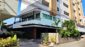 A modern building with a balcony, surrounded by greenery and potted plants. - Baan Manthana Hotel (Hua Hin)