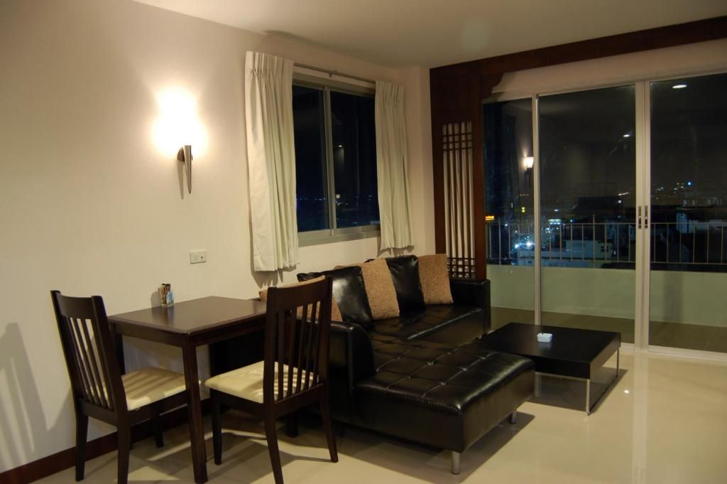 A modern living room with a sofa, chairs, a coffee table, and a dining table.