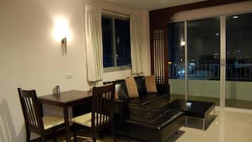 A modern living room with a sofa, chairs, a coffee table, and a dining table.