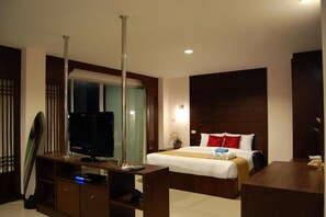 A hotel room with a bed, a TV, a desk, and a mirror.
