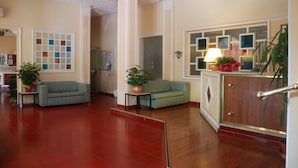 Un hall amplio con dos sofás, un mueble de madera y suelo de baldosas.