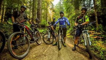 Un gruppo di ciclisti da mountain bike su un sentiero forestale, con le loro biciclette.
