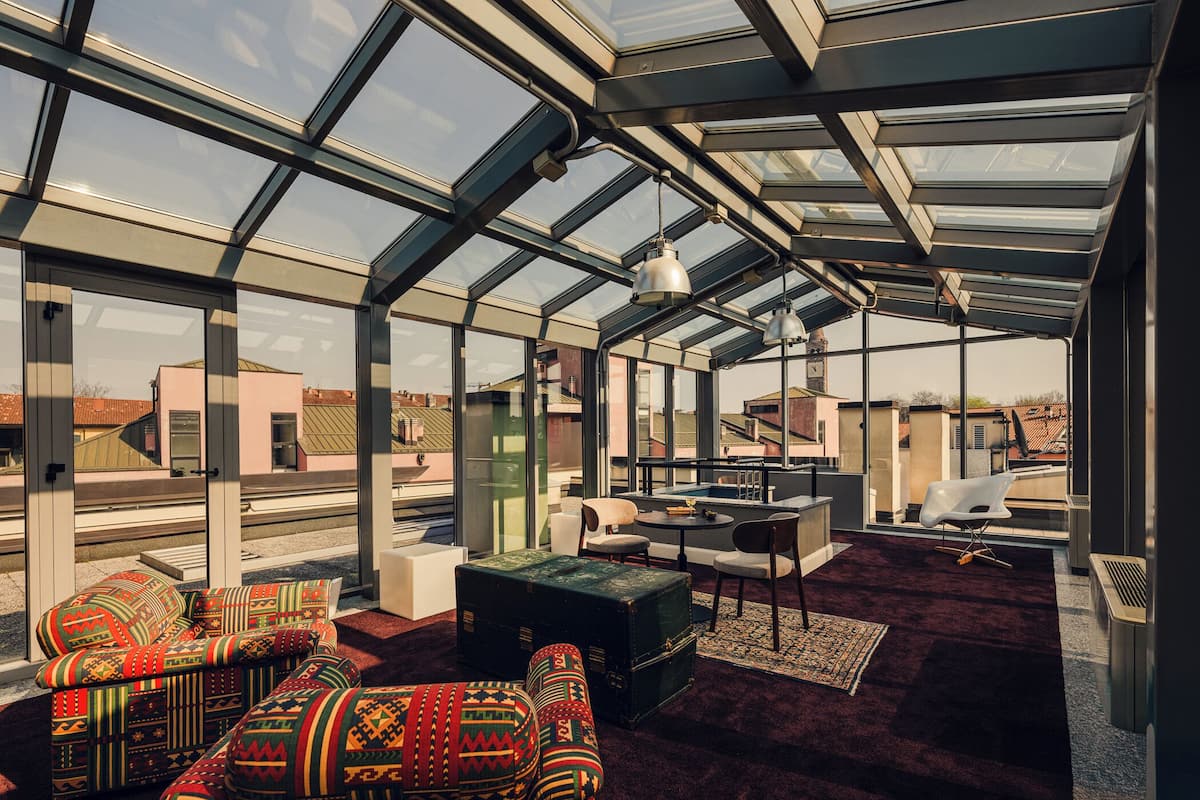 A modern interior with a glass ceiling, a sofa set, a table, and a chair.