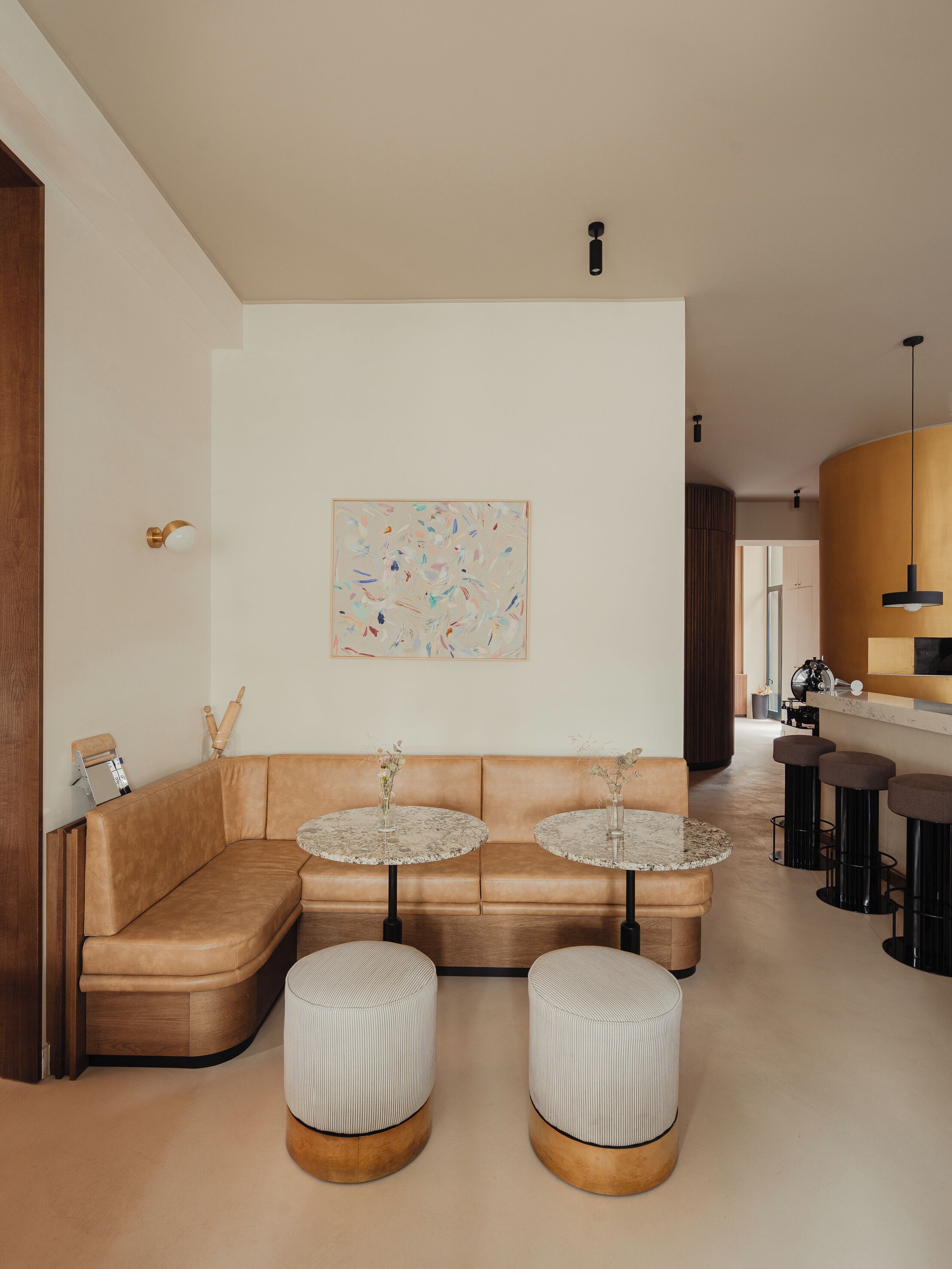 Ein modernes Wohnzimmer mit einer Couch, zwei runden Tischen und Poufs.