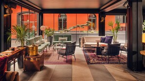 A modern lounge area with seating, a coffee table, and a potted plant. - Aethos Hotel Milan (Milan)