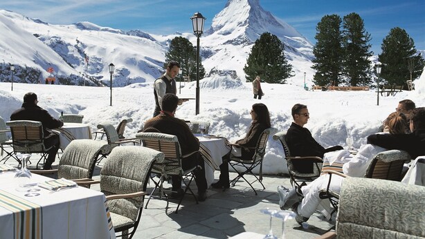 A restaurant with outdoor seating overlooking a snowy mountain landscape. - Good Value Apartments by MX Zermatt (Zermatt)