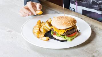 A plate with a hamburger and fries on a table.