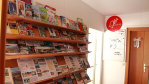 Una exhibición de folletos de viajes sobre estantes de madera en una habitación con una puerta de madera y una pizarra en la pared.