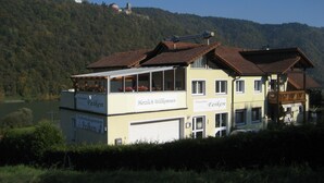 A two-story building with a sign reading "Herzlich Willkommen" and "Privatzimmer Feiken".